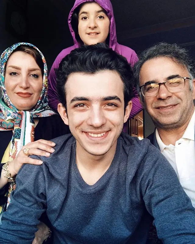 علی شادمان در کنار پدر و مادر و خواهرش با عکس